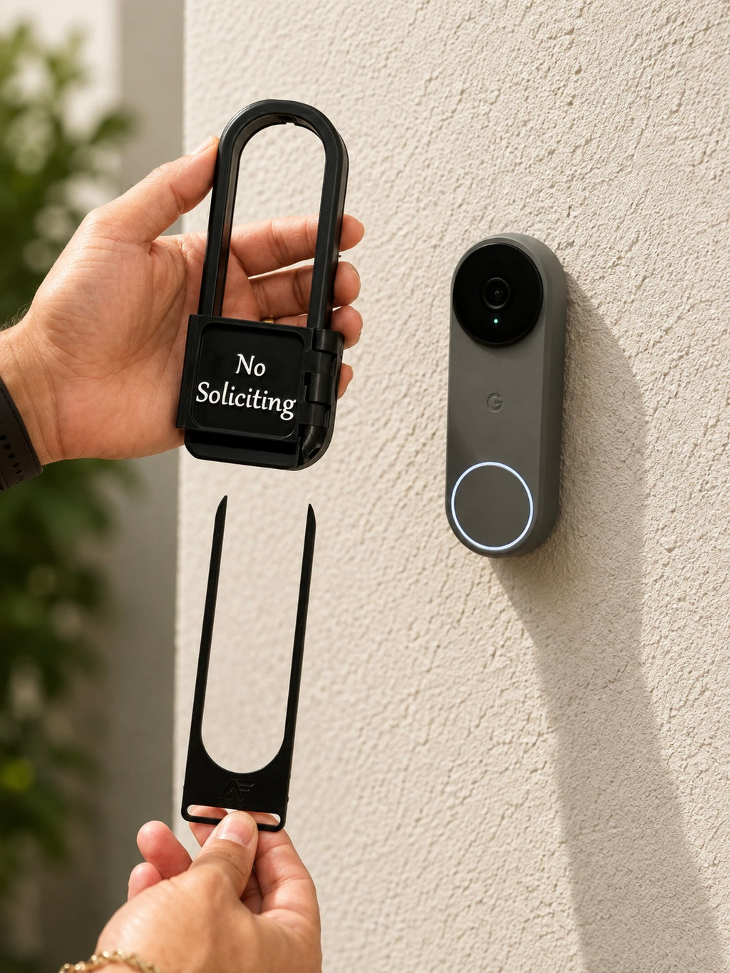 AvrenForge No Soliciting cover held beside a Nest Doorbell with the removal tool